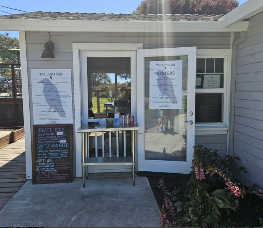 The Birds Cafe ordering window with menu boards for food, oysters, and drinks
