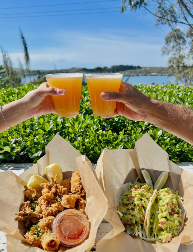Cheers with two beers over fish tacos and calamari on the patio